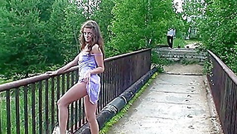 Petite chick does not shy to pose naked on the bridge