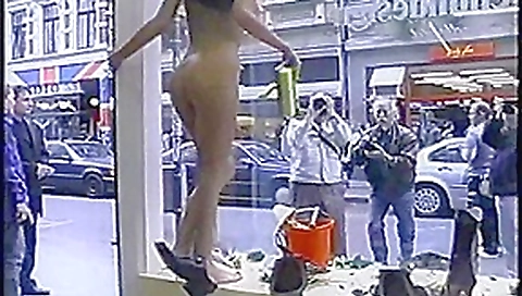 Nude girl washing windows in public