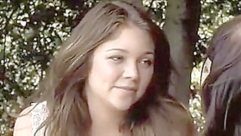 Sweet looking lesbians play with each other outside.